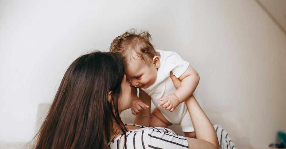Moeder met baby in haar armen – liefdevolle verbinding tijdens eerste levensfase